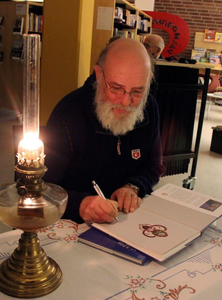 Signerar.  Allan Olsson fick signera sina och hustruns böcker om Kiddön när han berättat om skutskepparlivet.