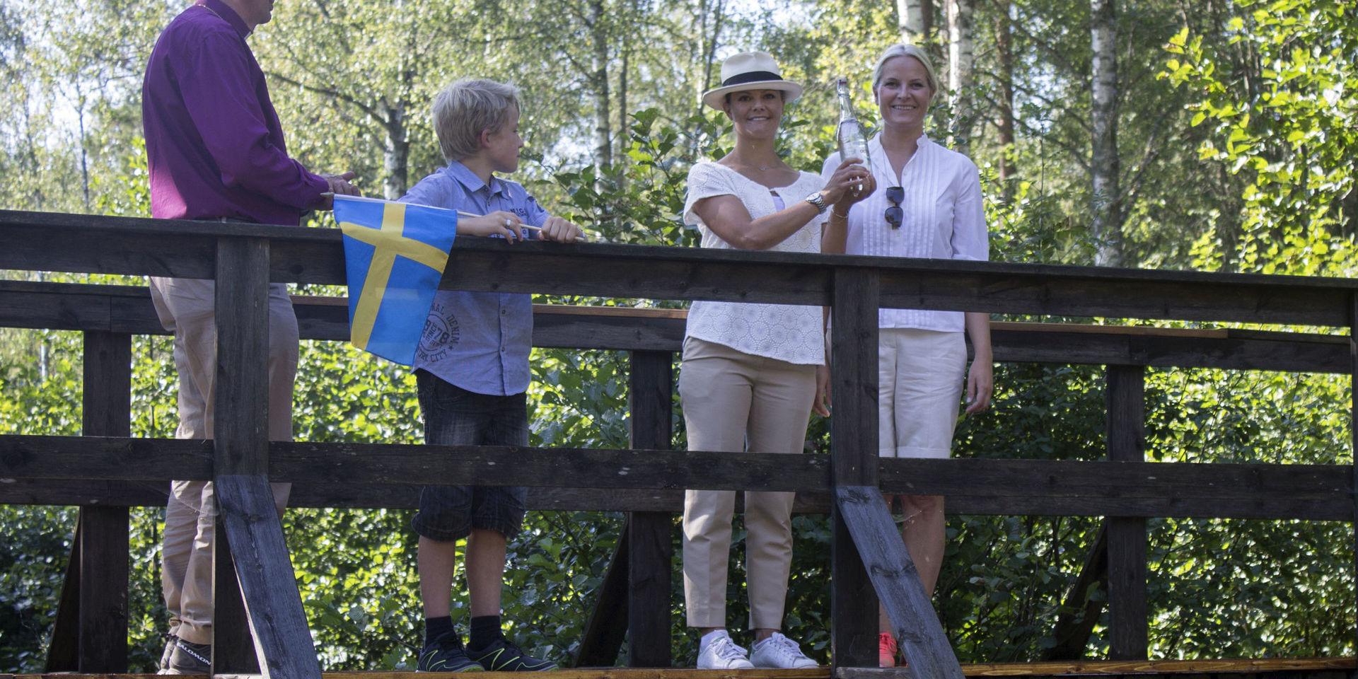 Kronprinsessorna Victoria och Mette-Marit vid svensk-norska gränsen på gångbron över Elgafallet 2015.