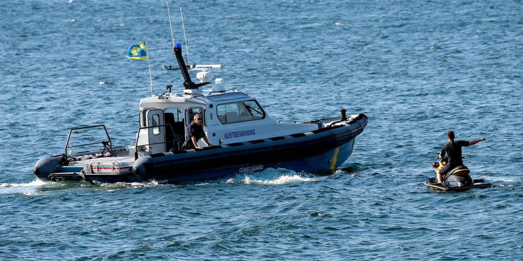 En polis ombord på en av Kustbevakningens båtar kontrollerar en vattenskoter. Arkivbild.