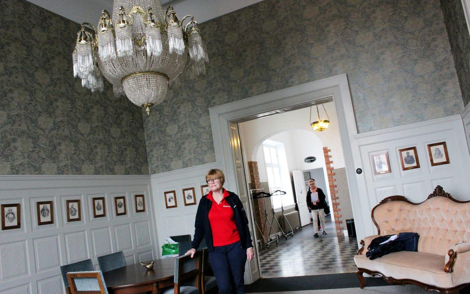 Strömstadsguiden Monica Olsson i Nämndernas rum. Kungabilderna på väggen är skänkta av Ivo Cramer.