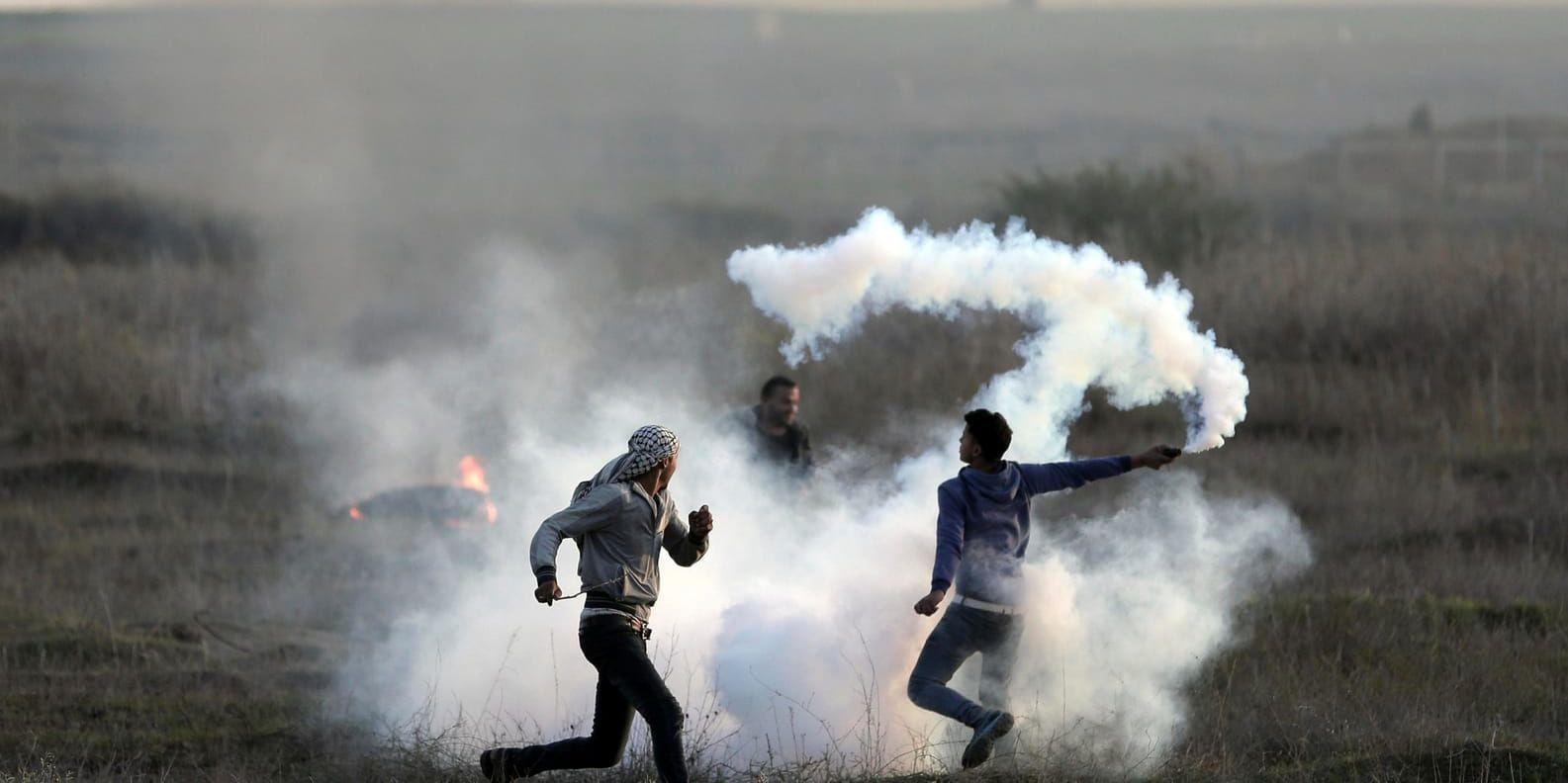 Palestinier kastar tillbaka tårgasprojektiler som israelisk militär skjutit över gränsen. På lördagen avslutades "vredens dag" som pågått i tre dygn med oroligheter i Gaza och på Västbanken.