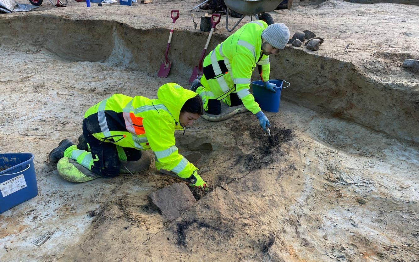 Arkeologerna Charlotte Nueva Finnebråten och Karu Kolesnikow Cavicchioli gräver fram runstenen.