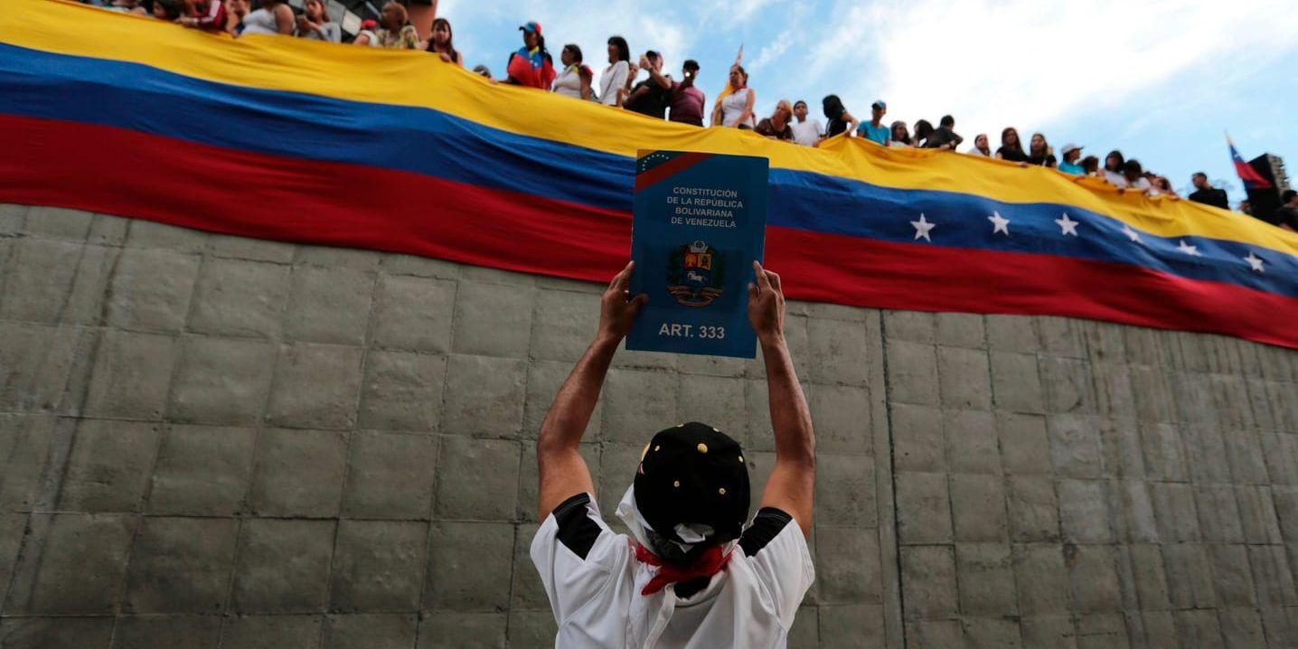 En demonstrant håller upp ett exemplar av konstitutionen, under en protest i huvudstaden Caracas mot Venezuelas president Nicolás Maduro.
