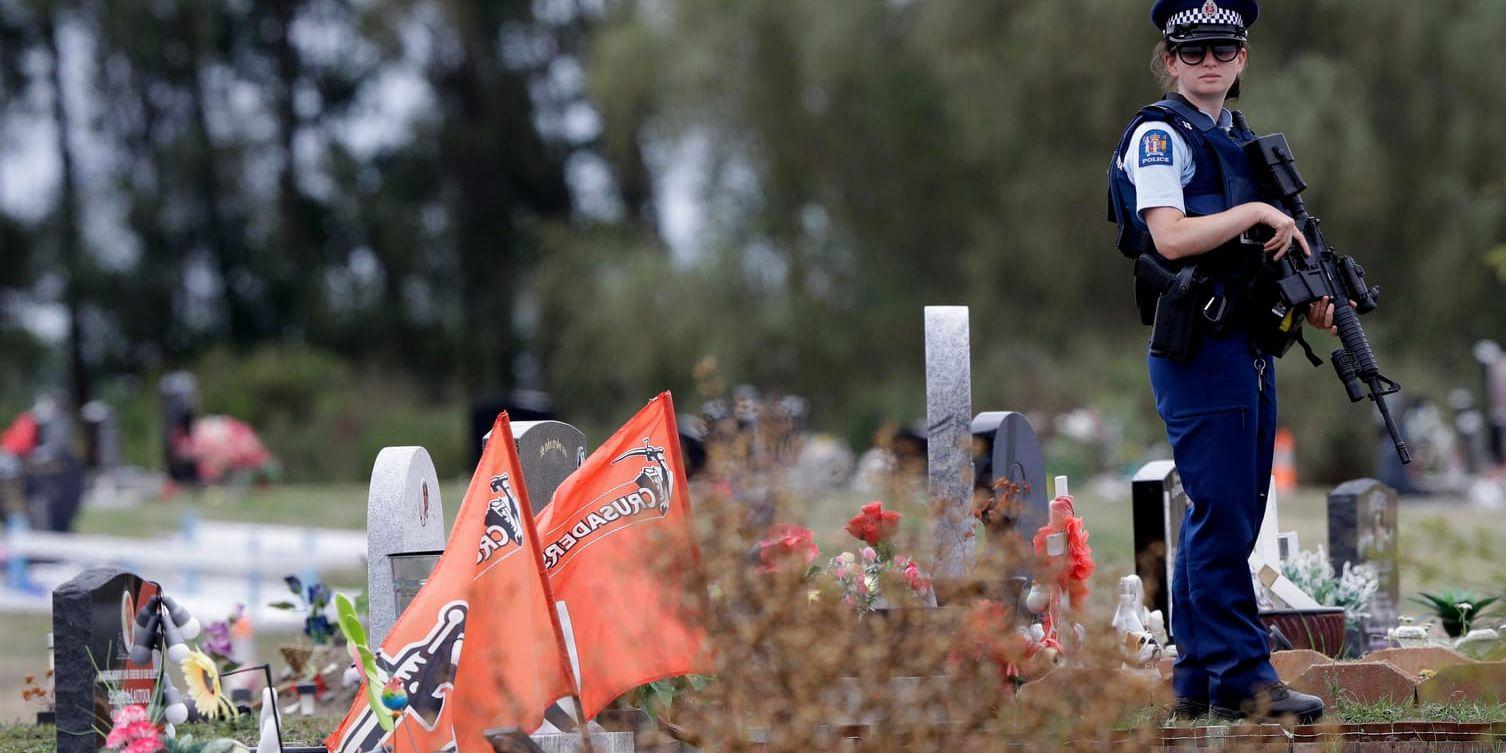 Polis bevakar en begravningsplats i Christchurch efter fredagens terrordåd.