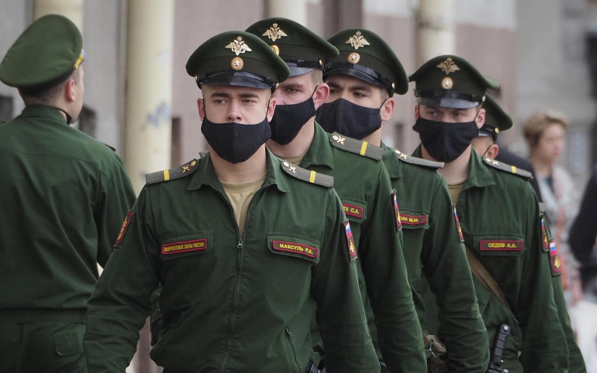 Soldater med ansiktsmasker marscherar i ryska S:t Petersburg. Landets dödstal är lågt i förhållande till antalet smittade.