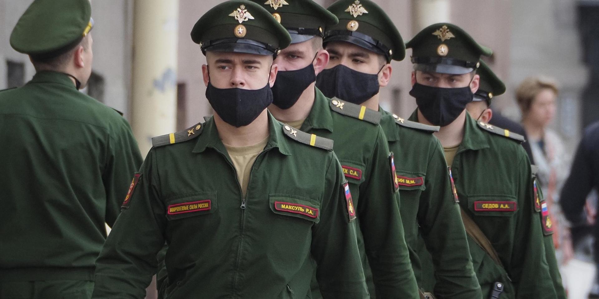 Soldater med ansiktsmasker marscherar i ryska S:t Petersburg. Landets dödstal är lågt i förhållande till antalet smittade.