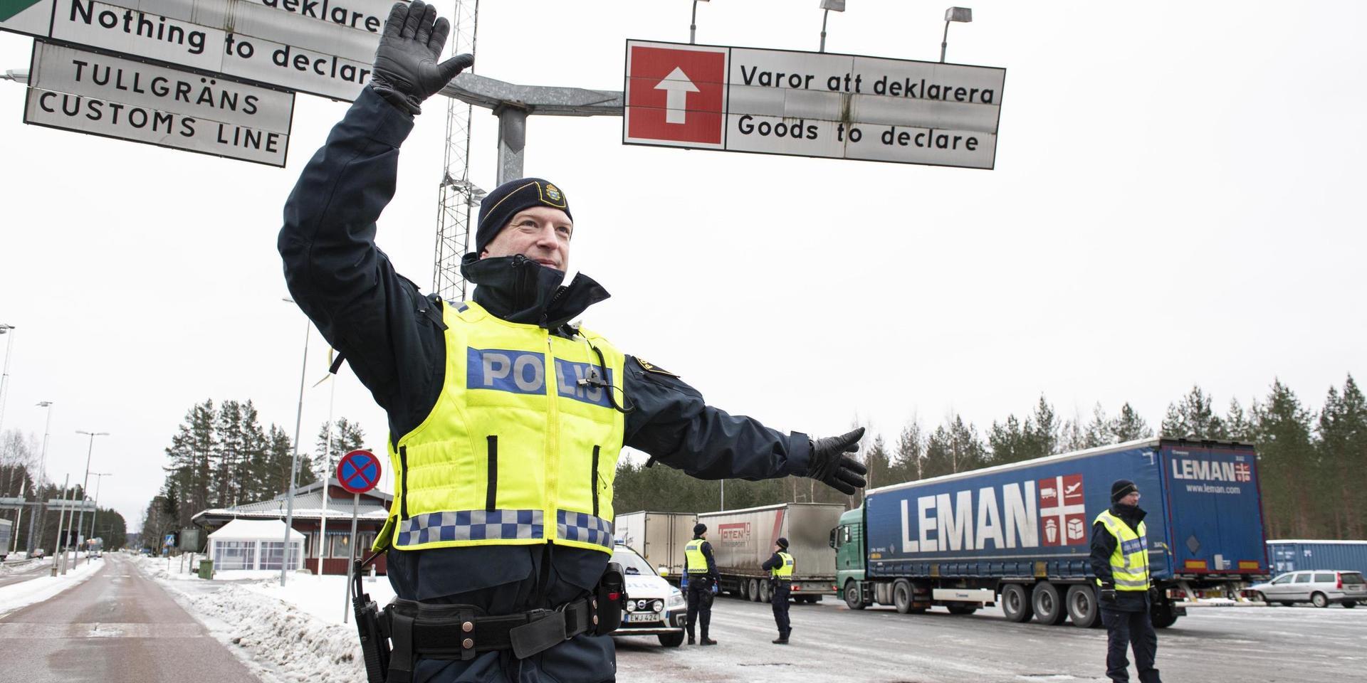 Andreas Berggren vinkar in bilarna som ska kontrolleras vid gränsen nära värmländska Charlottenberg.