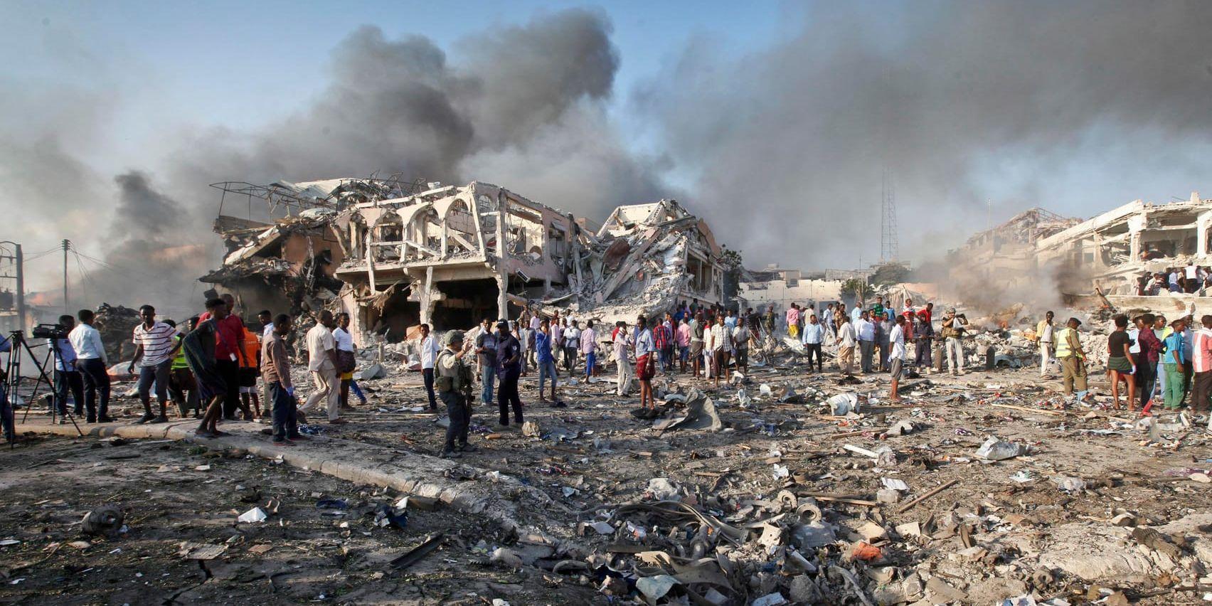Överlevande och ögonvittnen inspekterar förödelsen efter ett av gårdagens bombdåd i Mogadishu.
