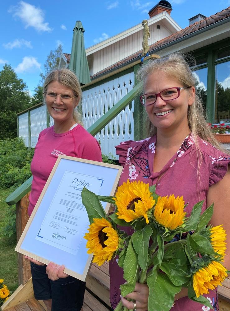 Ingela Holgersson (Skär-gårdsidyllen) och Elenor Olofsson från Tanums kommun delar på blom-buketten hälften till kommun och hälften till näringsliv.