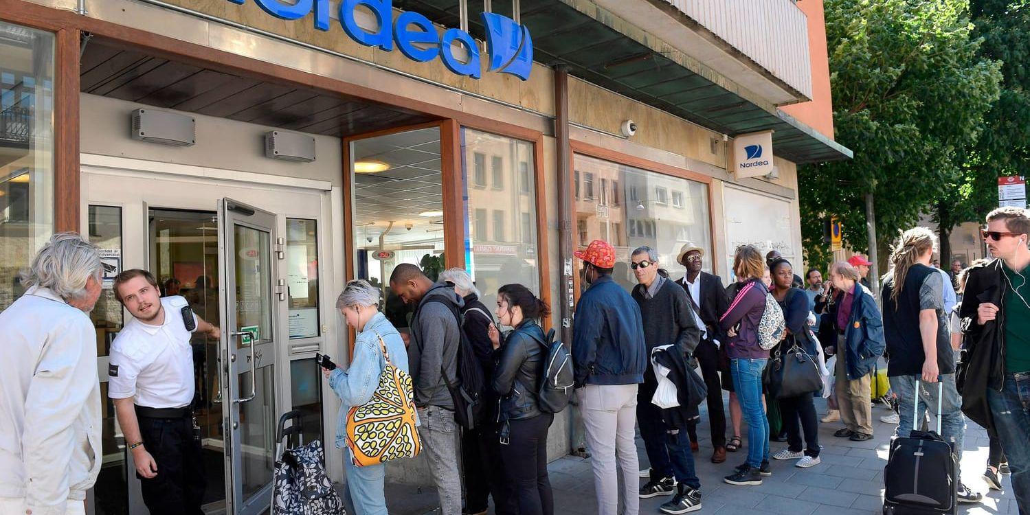 Köande kunder utanför bankkontor på Folkungagatan i Stockholm i väntan på att få sätta in mynt som blir ogiltiga.