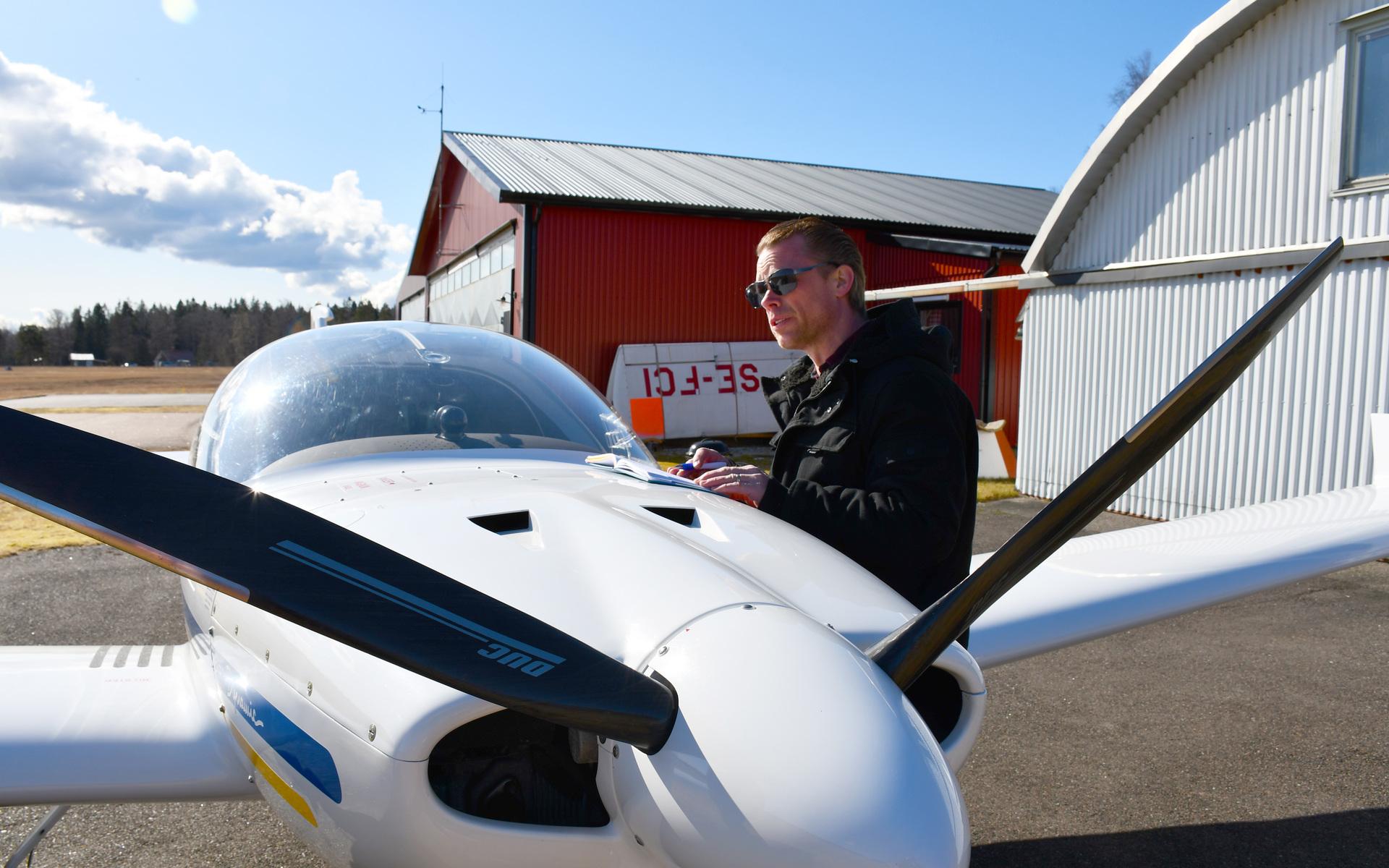 Thomas Björk inspekterar ett av flygplanen innan han ska ge sig ut på en flygtur. 
