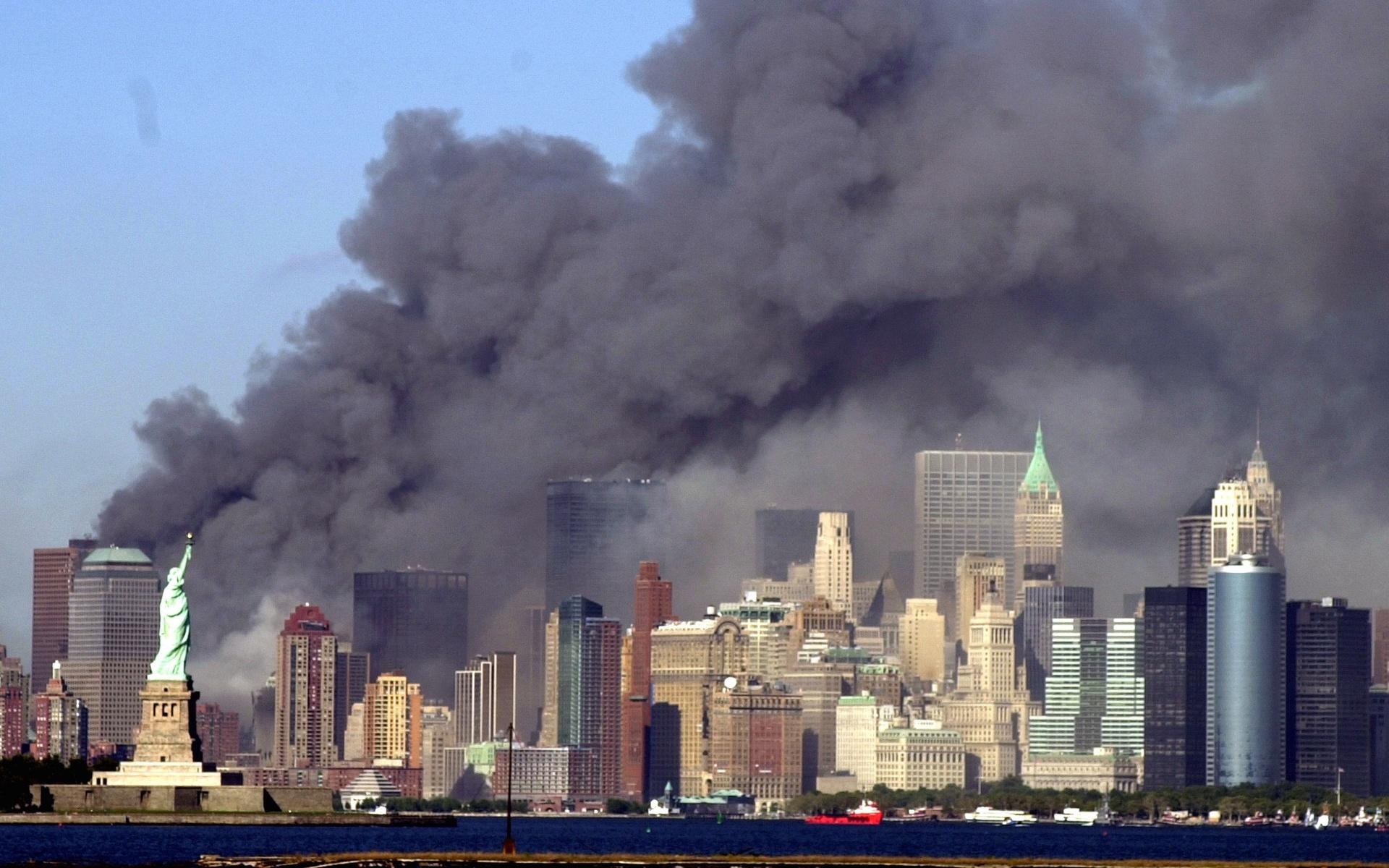 Tjock svart rök täckte området där World Trade Center-tornet stod för bara en liten stund sedan. Frihetsgudinnan i förgrunden. 
