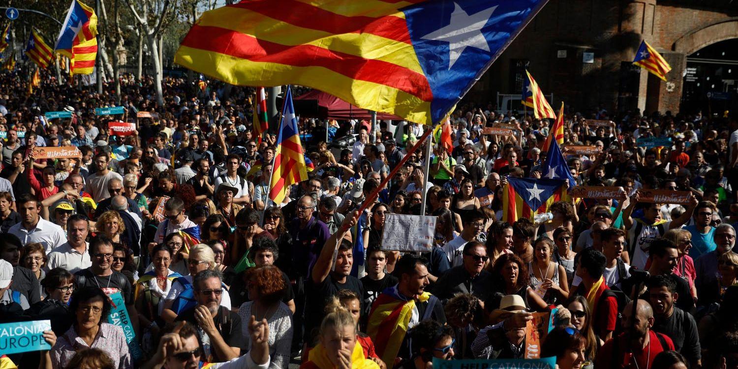 Demonstranter visar upp den katalanska flaggan under demonstrationer utanför det katalanska parlamentet i Barcelona.