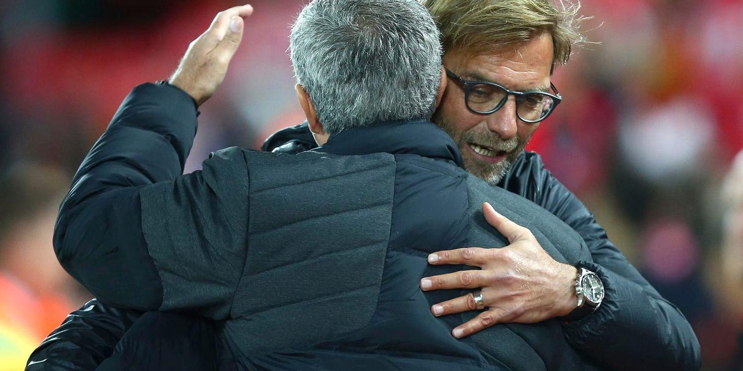 José Mourinho och Jürgen Klopp delar en kram. Båda tränarna delar även strategin att använda stämningen på Anfield till sin fördel i lördagens toppmöte. Arkivbild.