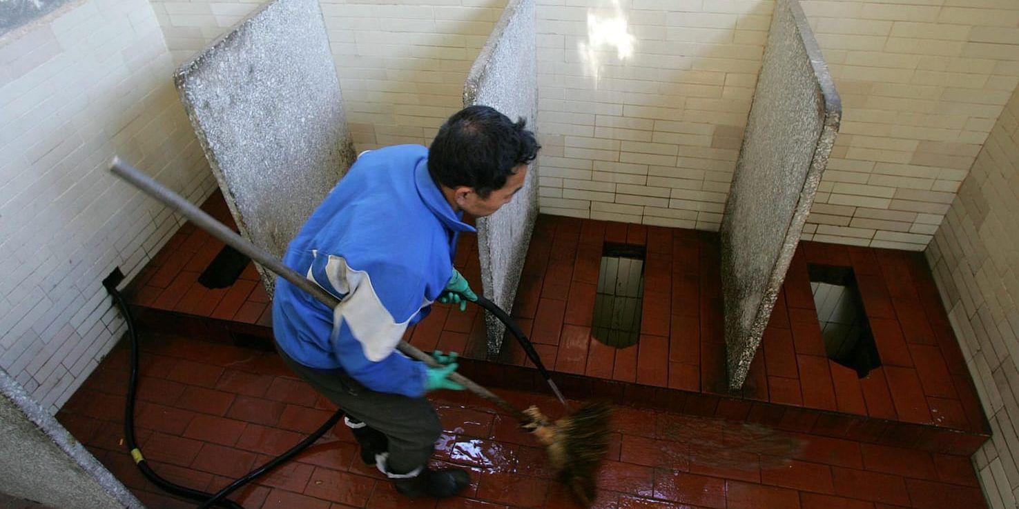 Städning av en offentlig toalett i Peking. Arkivbild.