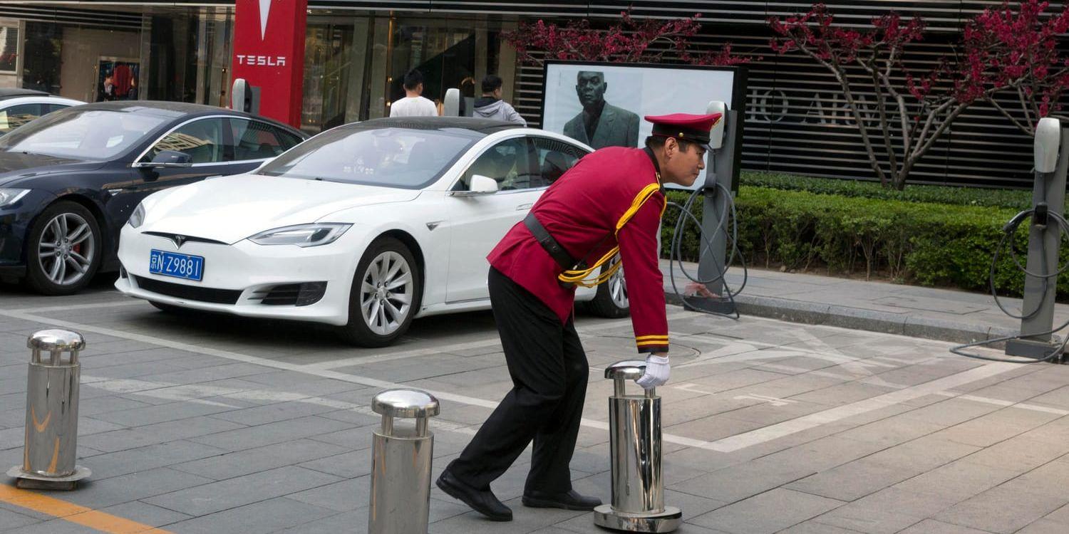 En vakt håller koll vid en laddplats för Tesla-bilar i Peking. Arkivbild.