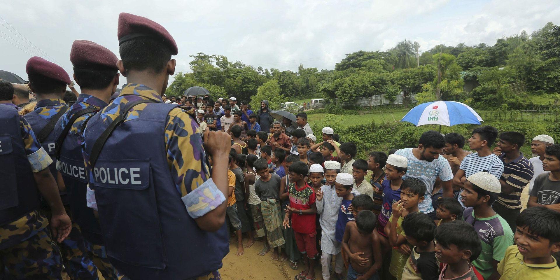 Unga rohingyer betraktar myanmariska och kinesiska tjänstemän som besöker flyktinglägret Cox's Bazar på torsdagen.