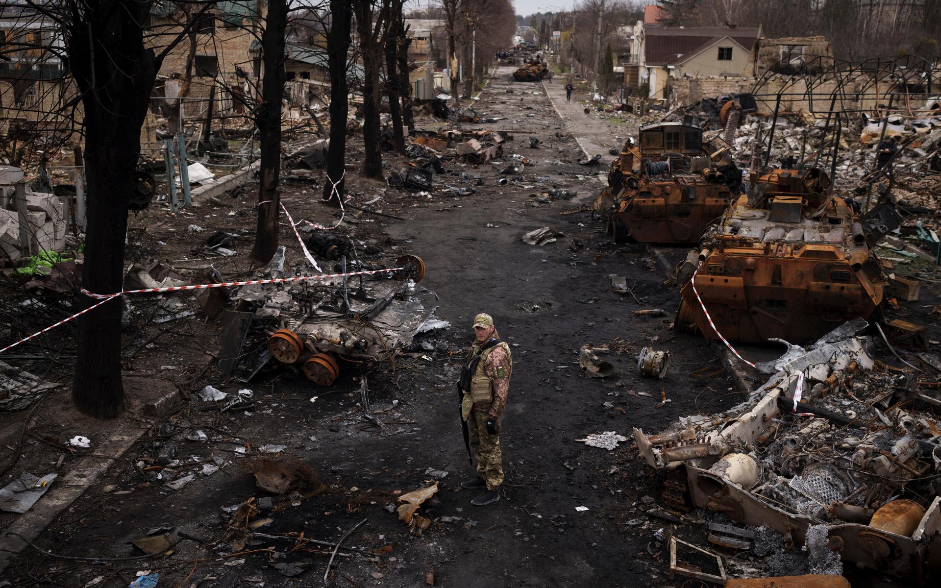 En ukrainsk soldat bland förstörda ryska stridsfordon. 