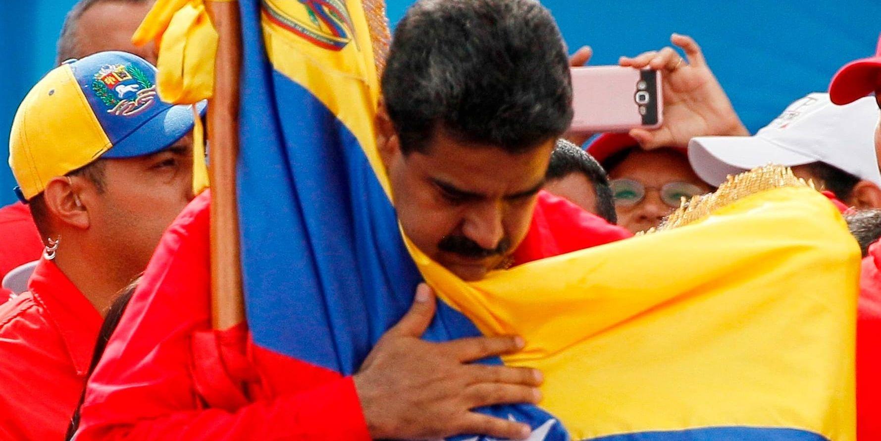 Venezuelas president Nicolás Maduro kramar om landets flagga. Arkivbild.